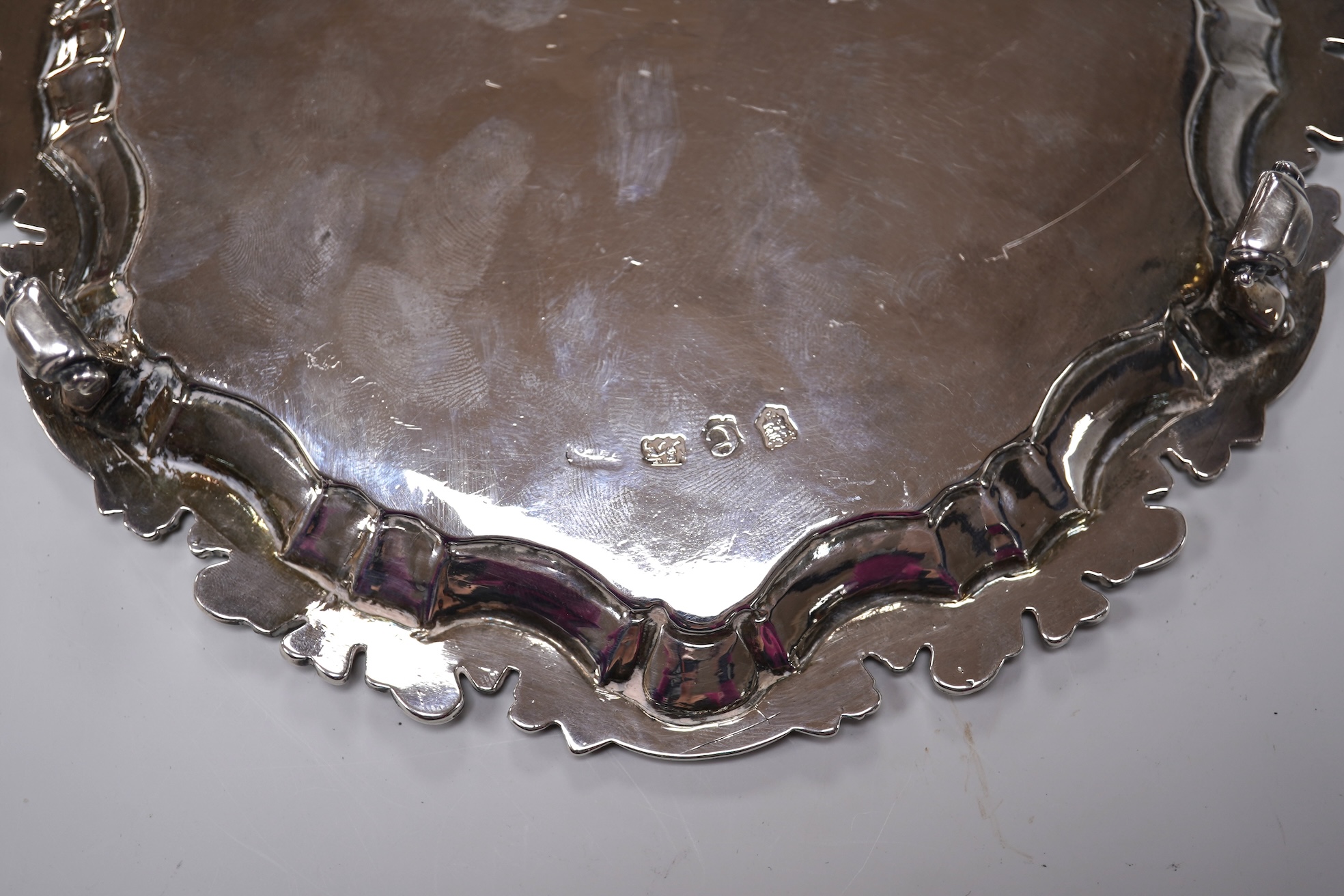 A George II silver card waiter, (with Howard Tripp crest?), of shaped circular form, on three scroll feet, maker's mark rubbed, London, 1740, 17.9cm, 9.4oz.